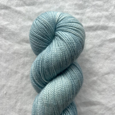 Light blue skein of yarn on a gray fabric background