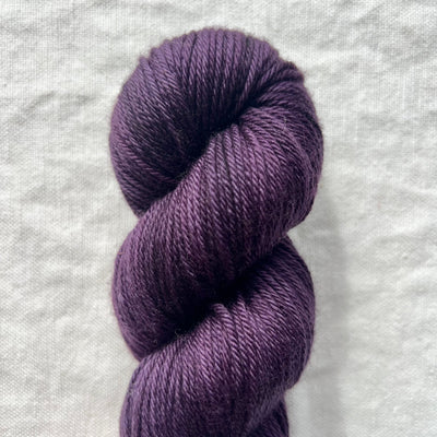 Purple skein of yarn on a light gray background