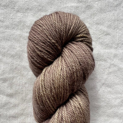 Brown skein of yarn on a textured gray background