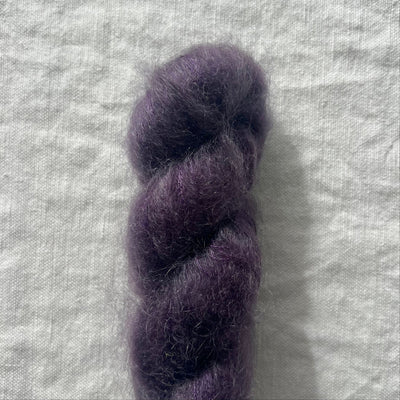 Purple skein of yarn on a textured gray background