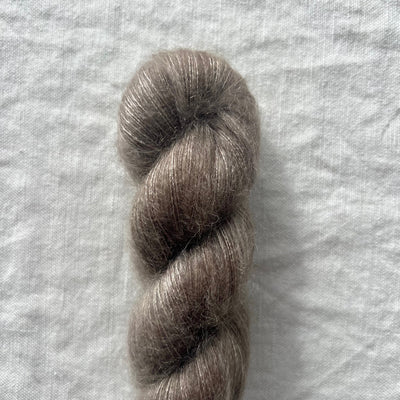 Single skein of gray yarn on a textured white background