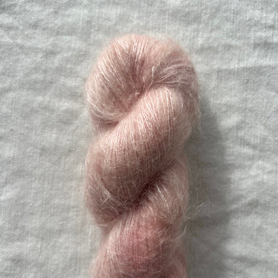 Skein of pink yarn on a textured gray background