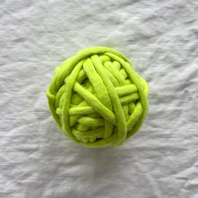Green ball of yarn on a textured gray surface