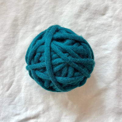 Blue ball of yarn on a white textured surface