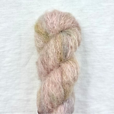 Pastel pink and beige skein of yarn on a light gray background
