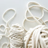 Two bundles of white yarn on a light  background