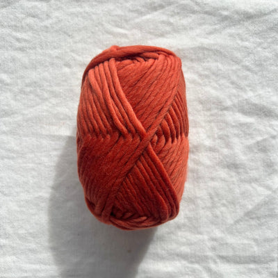 Ball of red yarn on white background