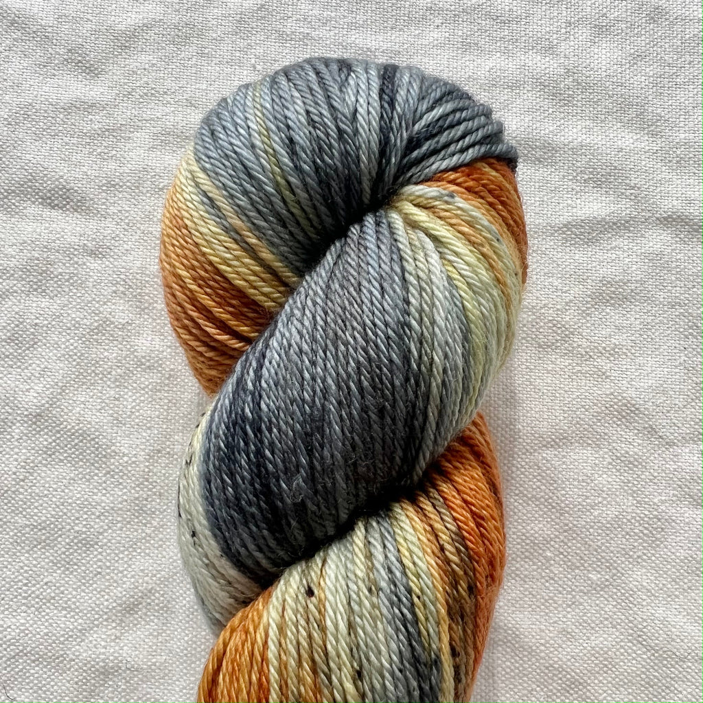 Multicolored skein of yarn on a textured fabric background