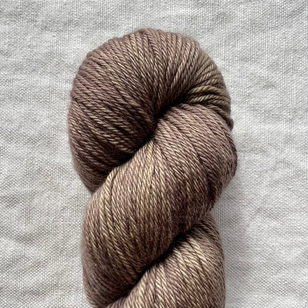 Brown skein of yarn on a textured gray background