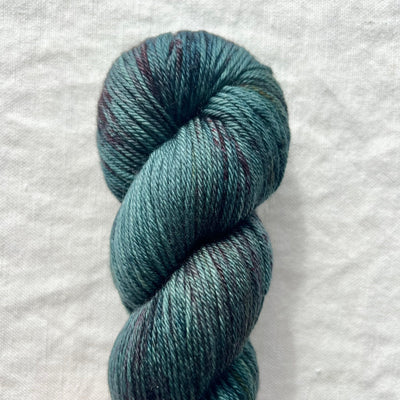 Blue skein of yarn on a white fabric background