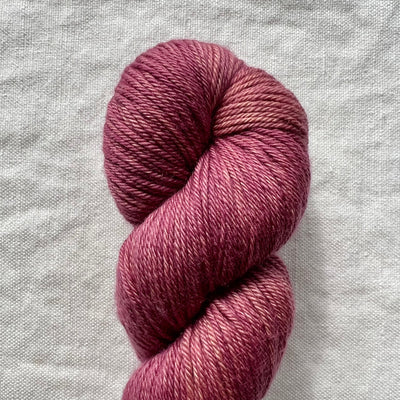 Ball of pink yarn on a textured gray background