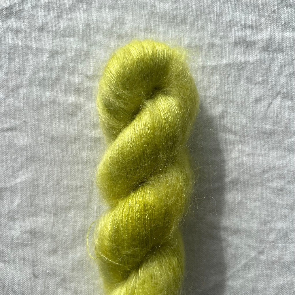 Neon yellow green skein of yarn on a light gray background