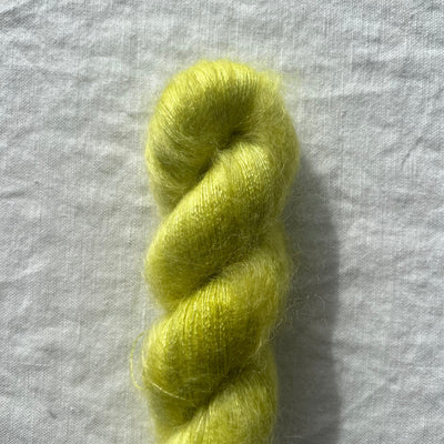 Neon yellow green skein of yarn on a light gray background