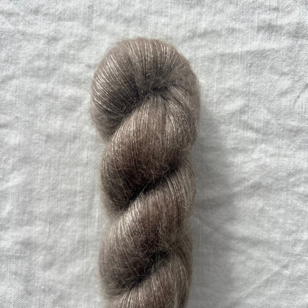 Single skein of gray yarn on a textured white background