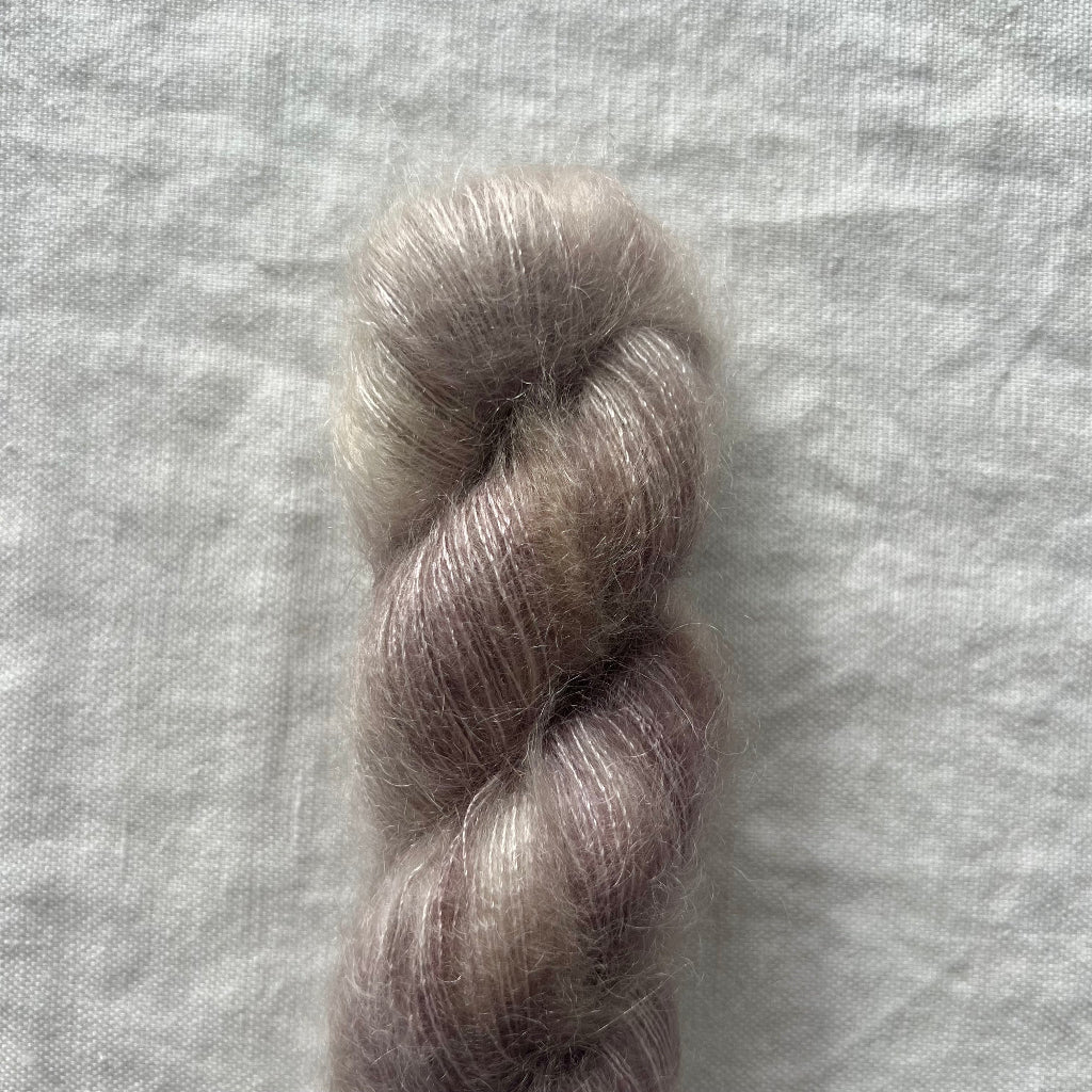 Single skein of gray yarn on a textured gray background