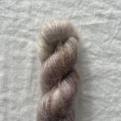 Single skein of gray yarn on a textured gray background