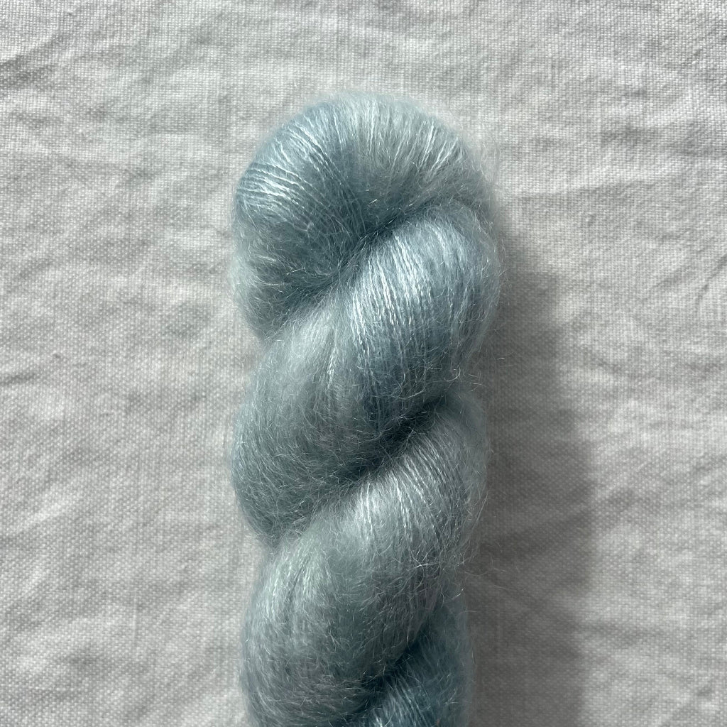 Blue skein of yarn on a textured gray background