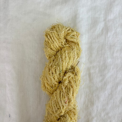 Yellow skein of yarn on a light gray background