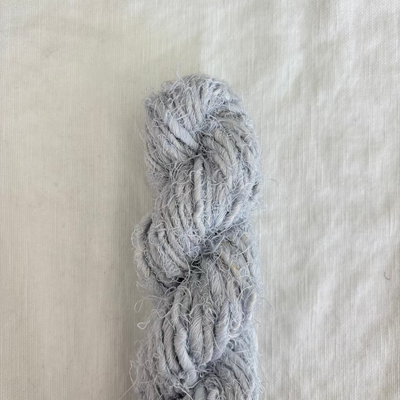 Light blue skein of yarn on a textured beige background
