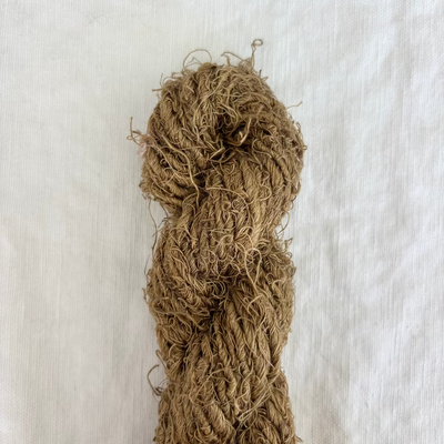 Ball of brown yarn on a light beige background