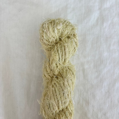 Ball of muted green yarn on a light gray background