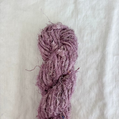 Purple skein of yarn on a textured beige background