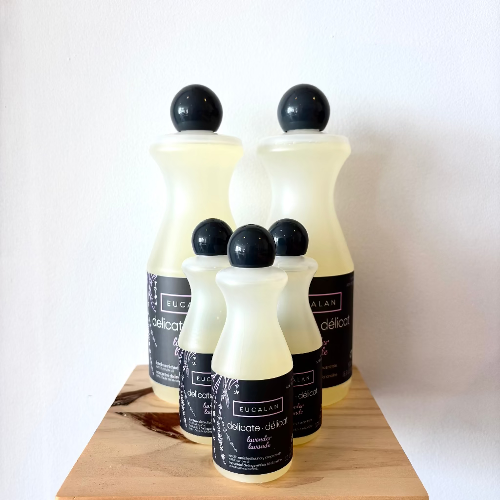 Set of Eucalan laundry detergent bottles on a wooden surface with a white background