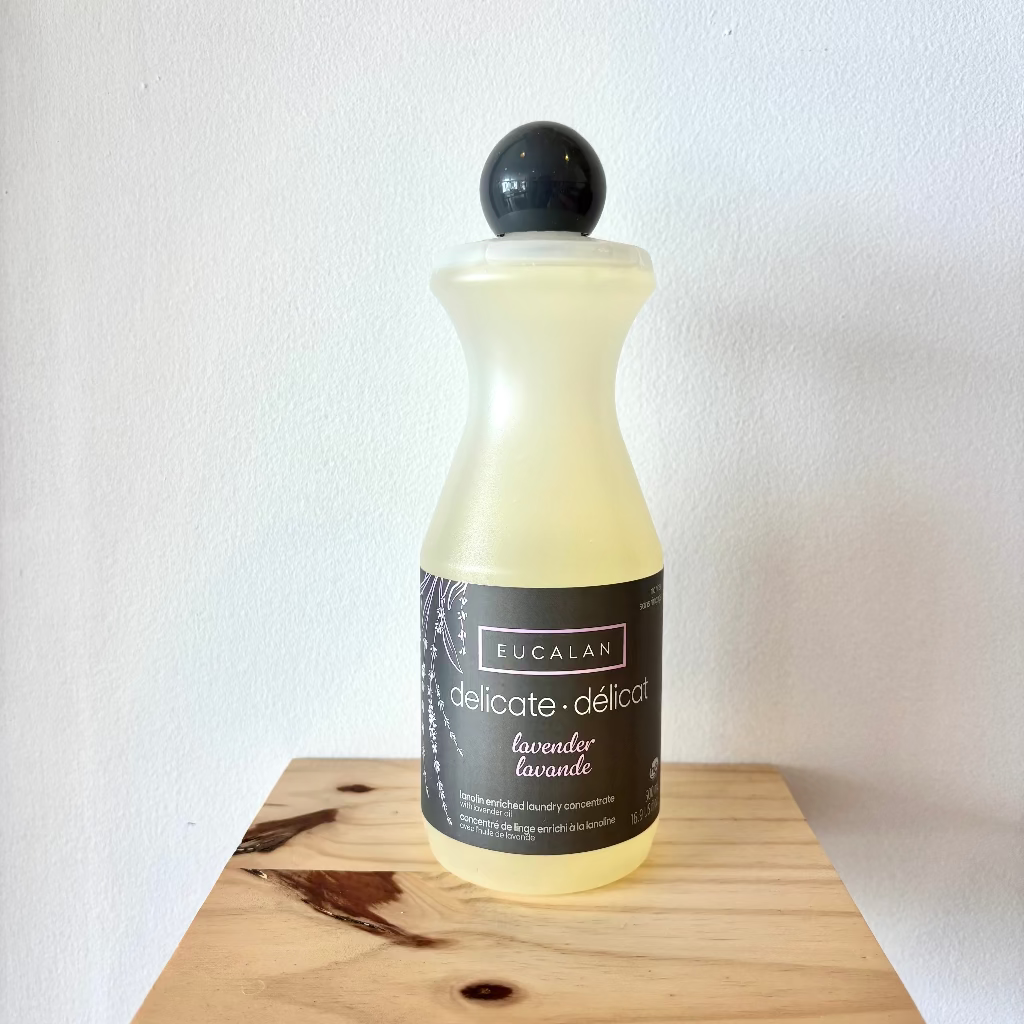 Bottle of Eucalan laundry detergent on a wooden surface with a white background