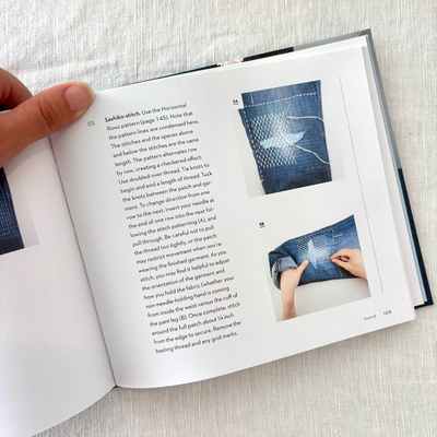 Open book with sewing instructions and images on a textured surface
