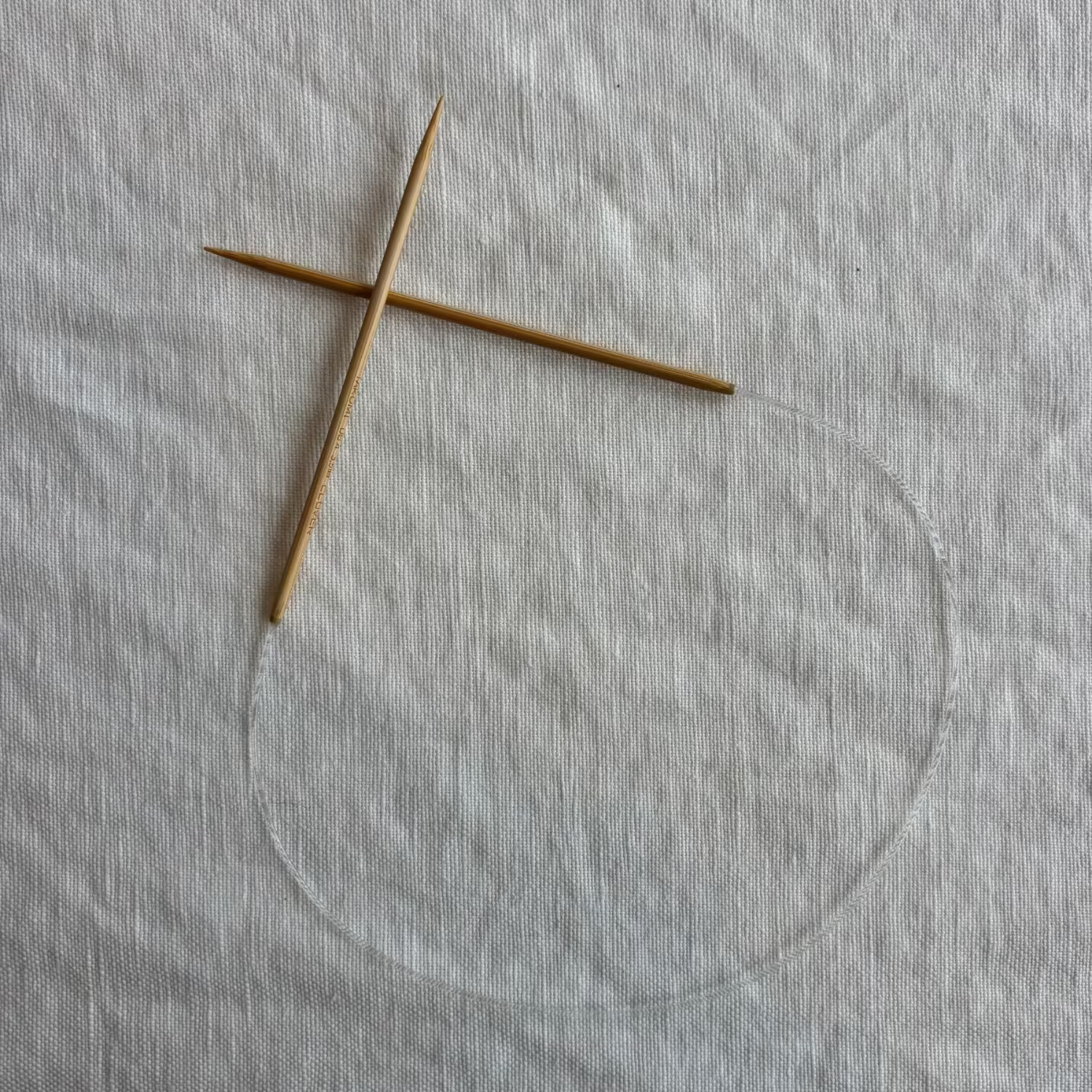 pair of wooden needles attached together with a cord.