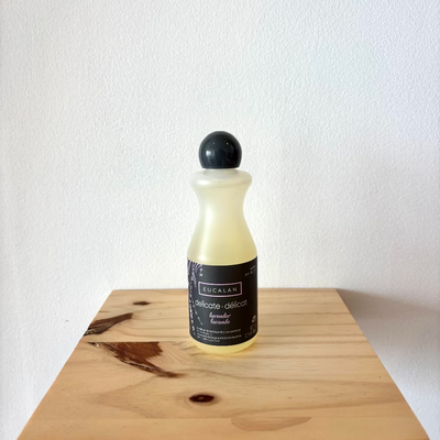 Bottle of Eucalan on a wooden surface with a white background