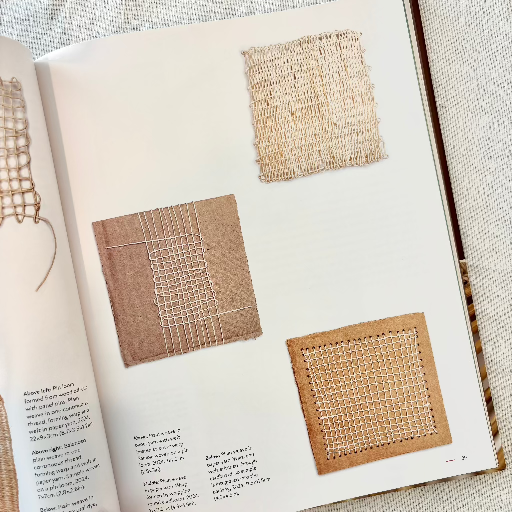 Open book showing fabric samples and text on a light background